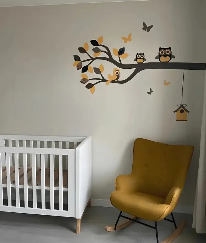 Okergele babykamer met uiltjes op een okergele tak.webp